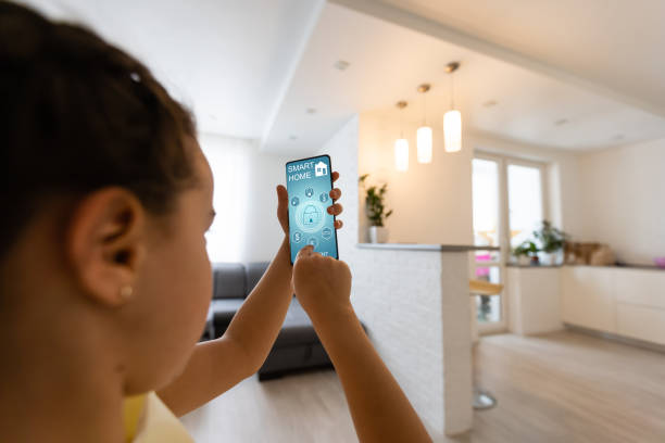 istock Shot of little girl using a domotic system with her digital tablet while standing at home. 1304763900