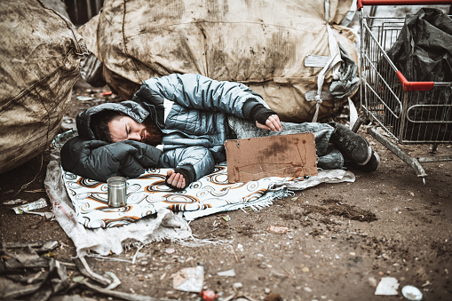 Sleeping Beggar Waiting For Charity While Sleeping With Sign