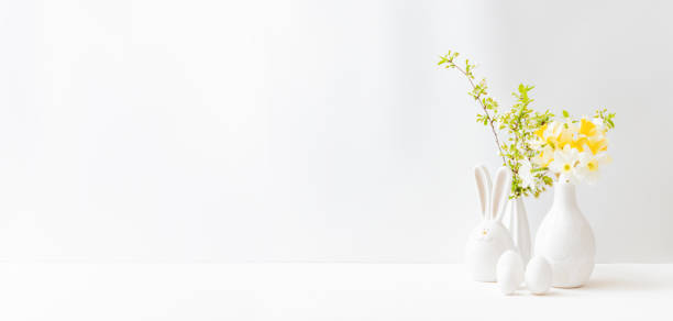 домашний интерьер с пасхальным декором. нарциссы в вазе, весенние цветы на светлом фоне - daffodil flower yellow vase стоковые фото и изображения