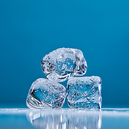 Ice Cubes stacked on top of each other on a blue background