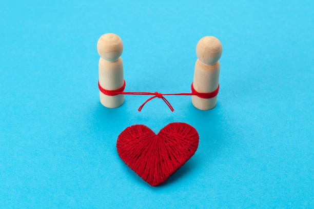 istock Connected figures of people and a red heart on a blue background. Restoring broken relationships. Successful solution to family problems 1304767642