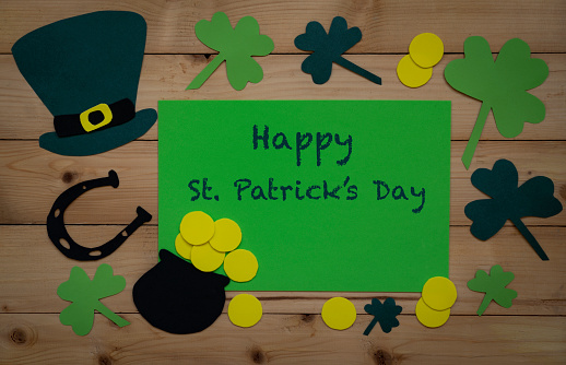 Patrick day. An iron cauldron full of gold coins in a leprechaun hat, isolated on a green background. 3d rendering