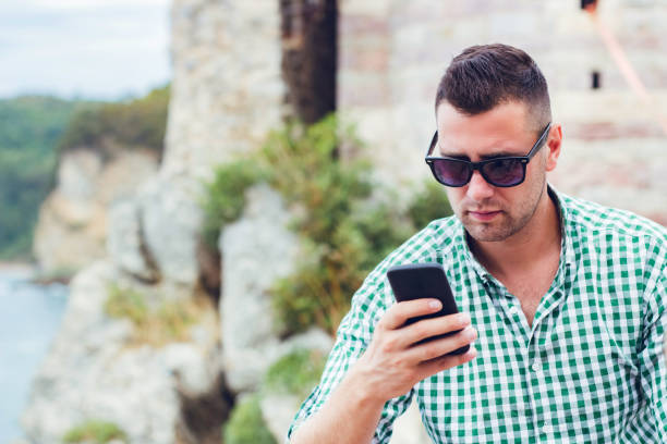 istock Man using cellphone outdoor in Budva Montenegro old town 1304770900