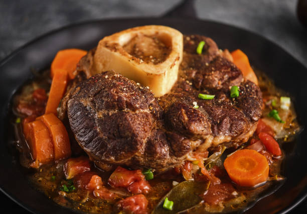 fatia de perna bovina com medula. cardápio italiano: bife de vial assado ossobuco alla milanese com molho vegetal. fosus seletivo. - veal meat osso buco beef stew - fotografias e filmes do acervo