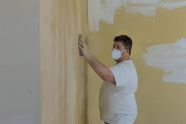 istock Contractor using sand trowel sanding the the plaster plasterboard 1304773431