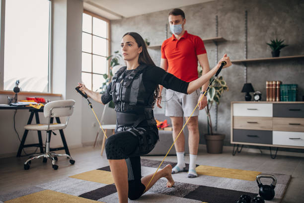 istock Exercising in electrical muscular stimulation suit at home 1304775218