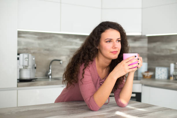 istock Woman drinking coffee in the kitchen 1304777738