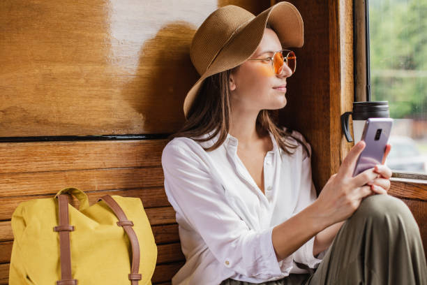istock Beautiful tourist woman using mobile phone in train 1304777790