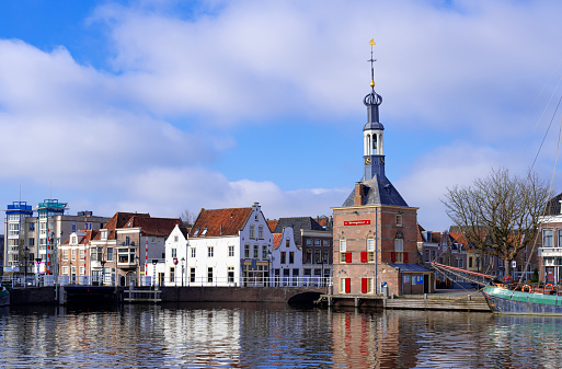 The Accijnstoren, excise tower, in Alkmaar, Netherlands, along a canal and 16th century houses
