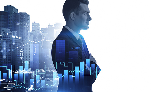 Portrait of confident young businessman standing in blurry city with double exposure of graphs. Toned image