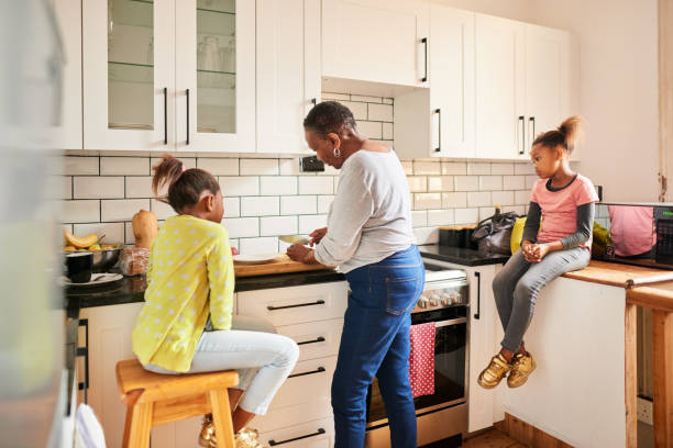 istock Grandmother making lunch at home for her two young granddaughters 1304783647