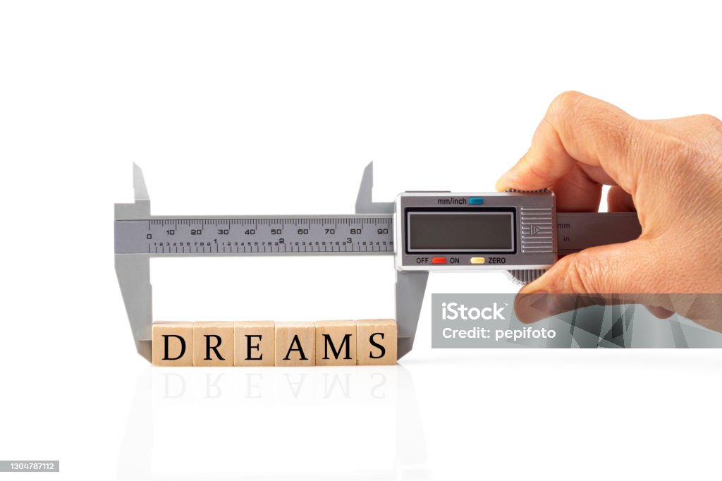Measurement of Dreams Caliper measures the word Dreams built of wooden cubes Accuracy Stock Photo