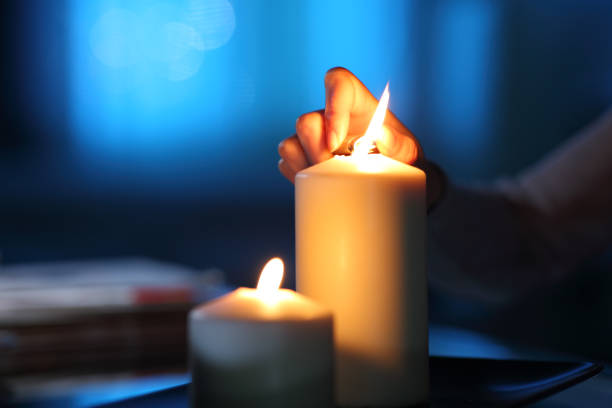 Woman hand lighting candle in the night at home Woman hand lighting candle in the night at home blackout photos stock pictures, royalty-free photos & images