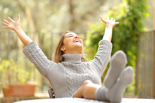 Excited woman celebrating in a garden at home