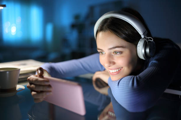 mujer feliz viendo los medios con teléfono y auriculares - parte de una serie fotografías e imágenes de stock