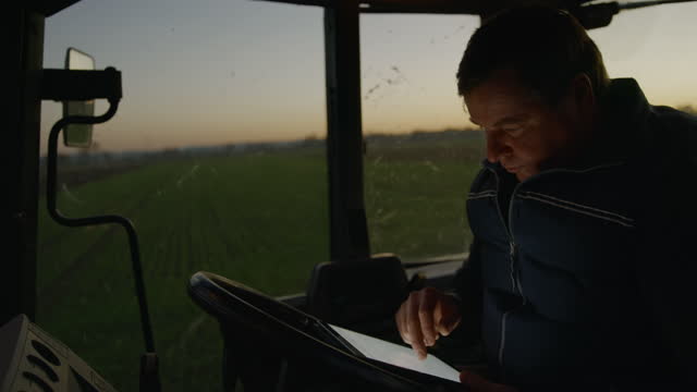SLO MO Mature farmer using a digital tablet inside of his tractor
