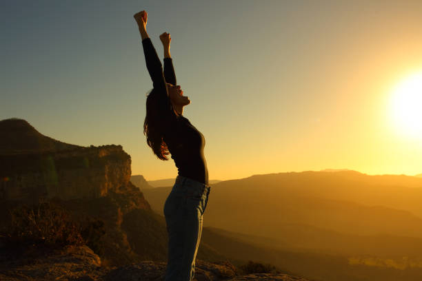 perfil de una mujer gritando levantando los brazos celebrando la puesta del sol - arms raised arms outstretched sky human arm fotografías e imágenes de stock