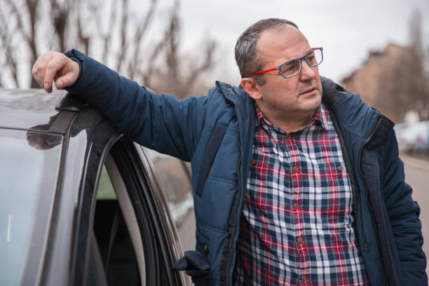 istock Serious man leaning onto his car 1304794636