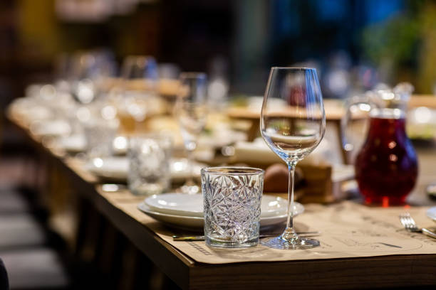 istock Tables set for an event party or wedding reception. luxury elegant table setting dinner in a restaurant. glasses and dishes. Empty glasses set in restaurant. Part of interior 1304795593