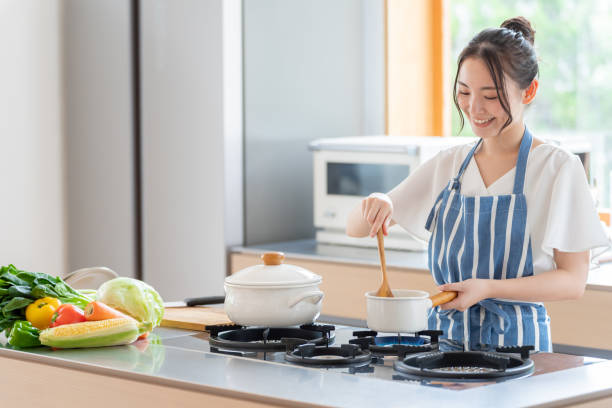 atractiva mujer japonesa cocinando en la cocina - preparar comida fotografías e imágenes de stock