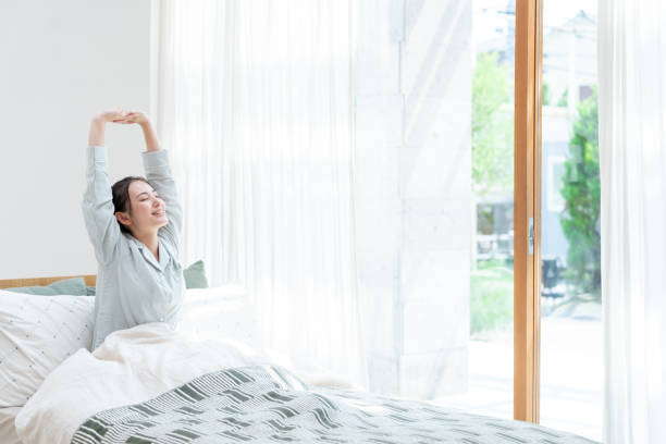 attractive japanese woman on the bed attractive japanese woman on the bed waking up stock pictures, royalty-free photos & images