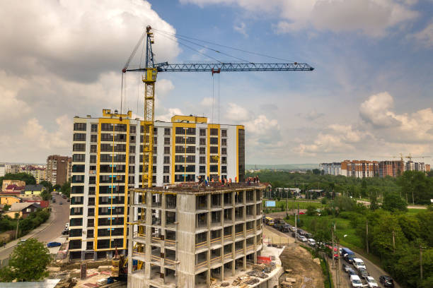 istock Kyiv, Ukraine - May 3, 2019: Workers working on concrete frame of tall apartment building under construction in a city. 1304800125
