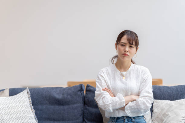 attraktive japanische frau im wohnzimmer - unbehaglich stock-fotos und bilder