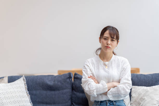 リビングルームで魅力的な日本人女性 - sulking ストックフォトと画像