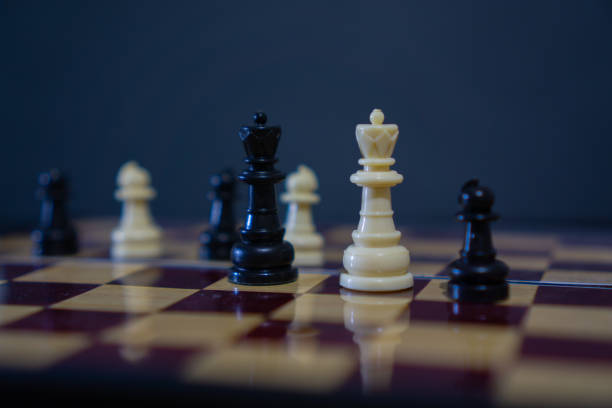 istock White Queen chess piece with other chess pieces softly blurred in background 1304803026