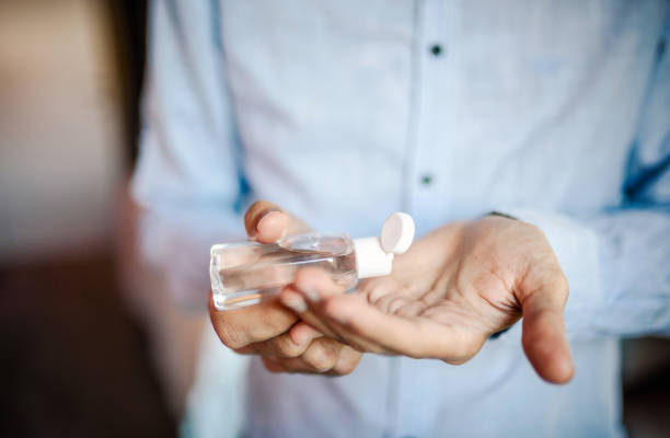 istock Man using sanitizer close up photo 1304804309