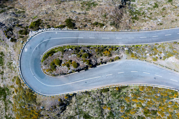 istock Top view aerial drone image of asphalt road 180 degrees curve surrounded by cliffs on Madeira island, Portugal. Safety transport concept shot. 1304812507
