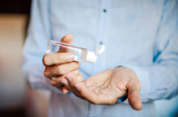 istock Man using sanitizer close up photo 1304815918