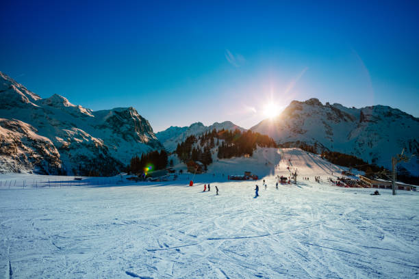 Last rays of sunset light over snow ski resort in French Alps in Savoie region