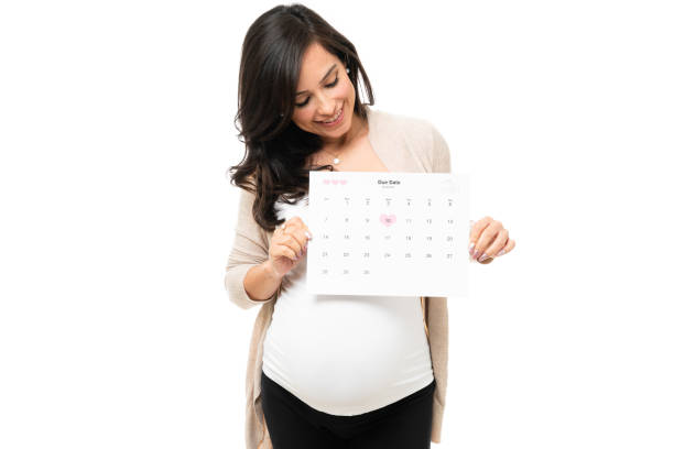 Pregnant woman marking her due date on a calendar