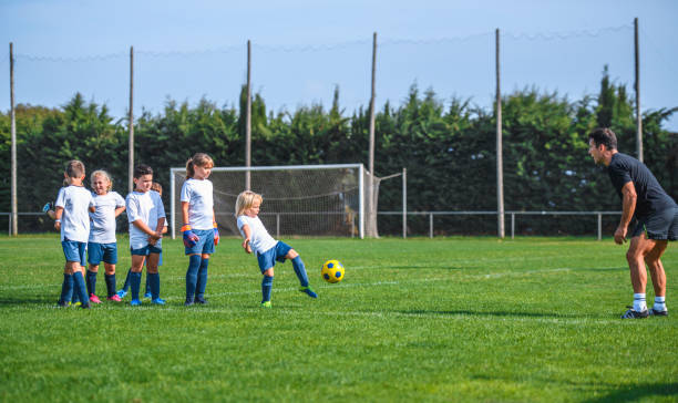 istock Coach Watching Young Footballers Doing Kicking Drill 1304821232