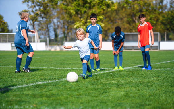 istock Mixed Age Young Boy Footballers Practicing Kicks 1304821235