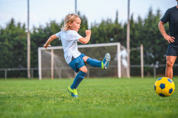 istock Coach Watching 6 Year Old Boy Footballer Practice Kicking 1304821241