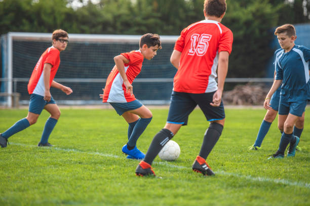 red jersey footballers controlling ball in training match - 2997 stock-fotos und bilder