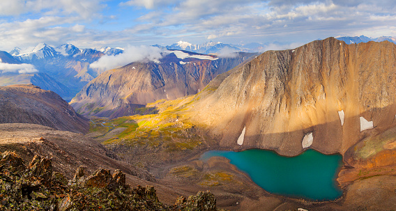 Mountain landscape, Altai. Lake in a deep gorge, colored rocks, morning light. Summer travel in the mountains, hiking.