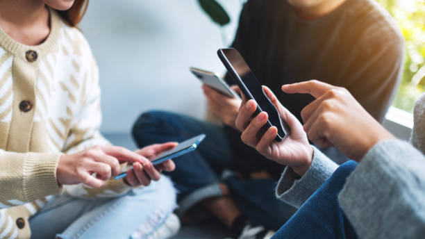 istock Group of young people using and looking at mobile phone together 1304825309