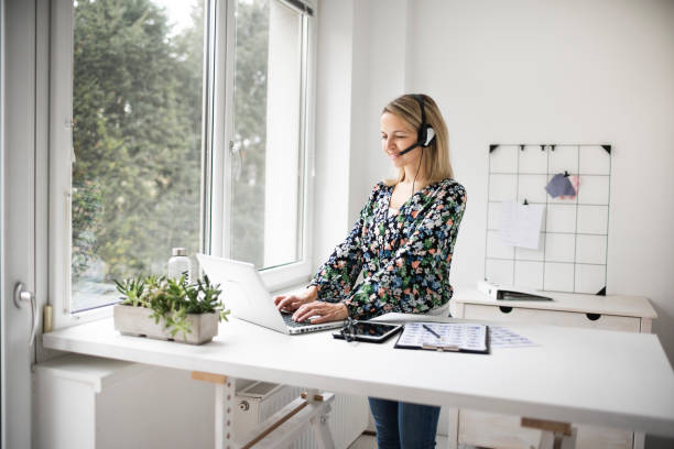 Businesswoman working at ergonomic standing desk Fit Businesswoman working at ergonomic standing desk standing desk photos stock pictures, royalty-free photos & images