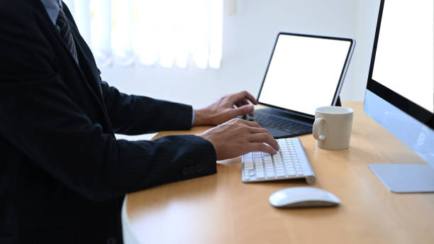istock Cropped shutoff businessman working with multiple devices oat office desk. 1304832310