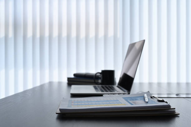 istock Modern workplace with computer laptop, document and coffee cup on dark office desk. 1304832389