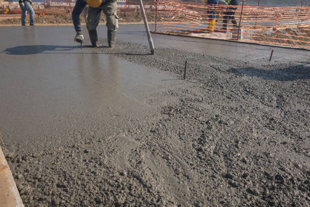 istock Construction worker levels freshly cast concrete with bull float 1304833158