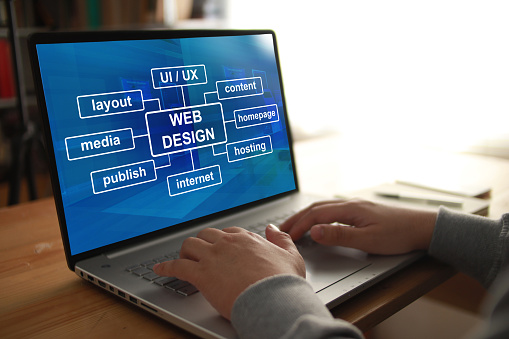 Persona anónima escribiendo en portátil con programa de diseño web que se muestra en la pantalla. Diseño del diseño del sitio web de UI UX photo