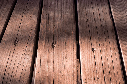 Close-up of a surface of heavily weathered old floorboards.