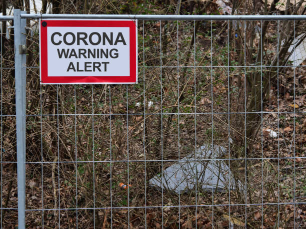 istock Fence at a construction site with warning signs Covid 19 no Entry 1304841100