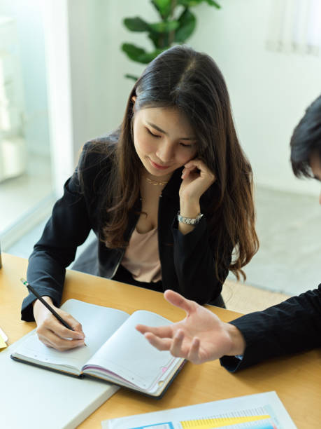 istock Businesswoman noting on blank notebook while meeting with coworker 1304842092