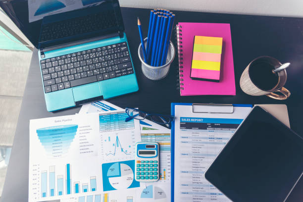 istock Office laptop business financial document chart and graph on wooden table with coffee cup. Flat lay notebook computer laptop on office desk. No people business graph chart mockup on business workspace 1304843031