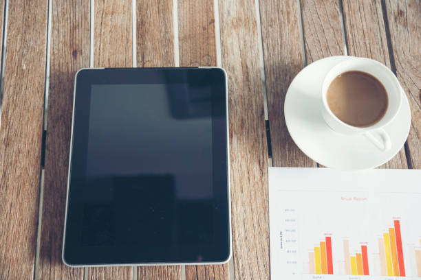 istock Office laptop business financial document chart and graph on wooden table with coffee cup. Flat lay notebook computer laptop on office desk. No people business graph chart mockup on business workspace 1304843129